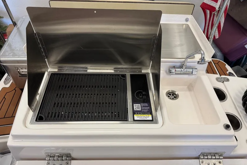 Slide: The Image of Outdoor kitchen setup on 2025 Ranger Tugs R-27 with grill and sink. - 18