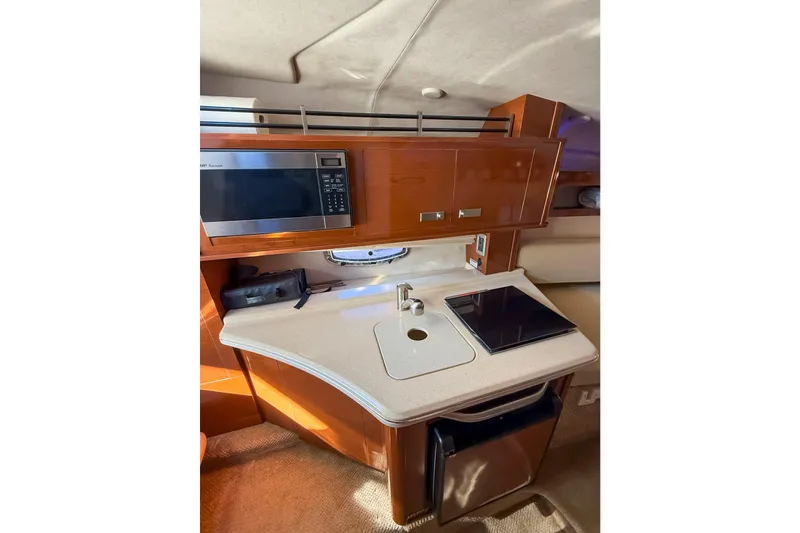 Slide: The Image of 2009 Sea Ray 270 Sundancer galley with microwave, sink, and stove. - 10