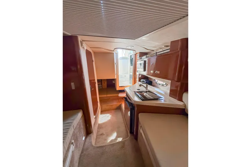 Slide: The Image of Interior of 2009 Sea Ray 270 Sundancer boat, featuring kitchenette and seating area. - 12