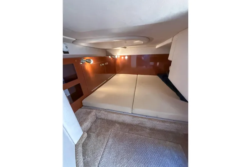 Slide: The Image of 2009 Sea Ray 270 Sundancer cabin interior with cushioned seating and ambient lighting. - 13