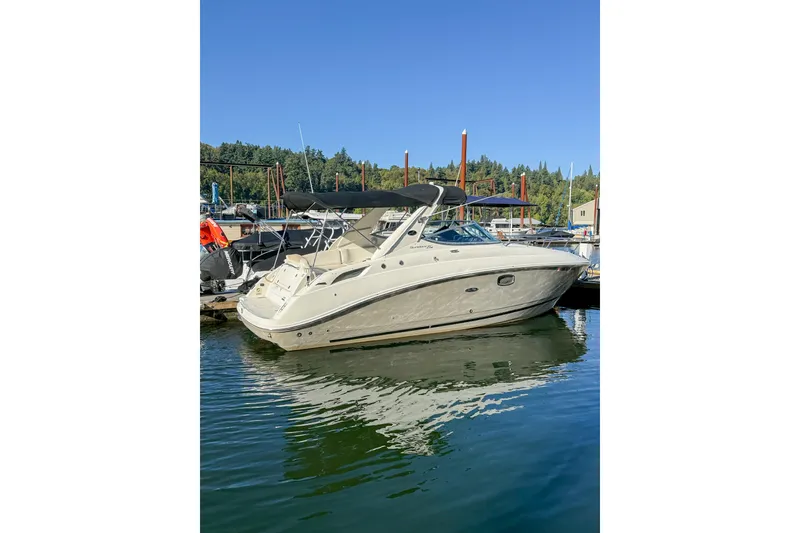 Slide: The Image of 2009 Sea Ray 270 Sundancer boat docked in a marina under clear blue sky. - 21