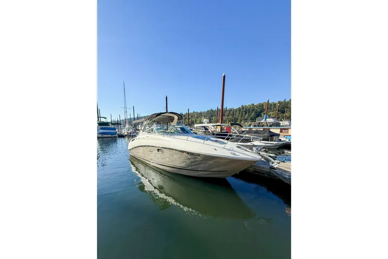 Slide: The Image of 2009 Sea Ray 270 Sundancer boat docked in a marina under clear blue sky. - 24