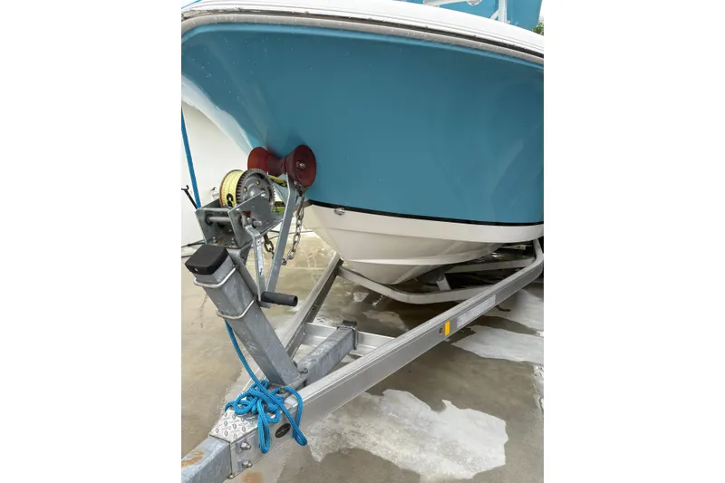Slide: The Image of 2019 Release 210 RX boat on trailer, blue hull, secured with winch and rope. - 2