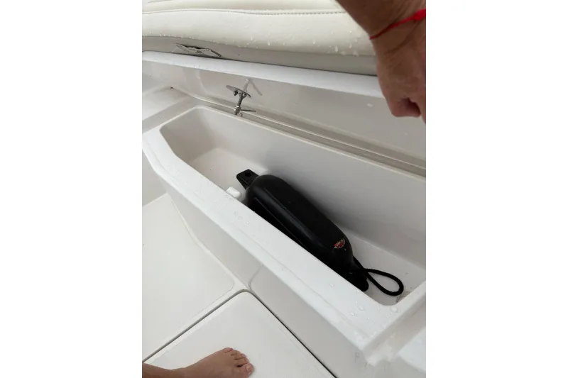 Slide: The Image of Open storage compartment in 2019 Release 210 RX boat with black fender inside. - 8