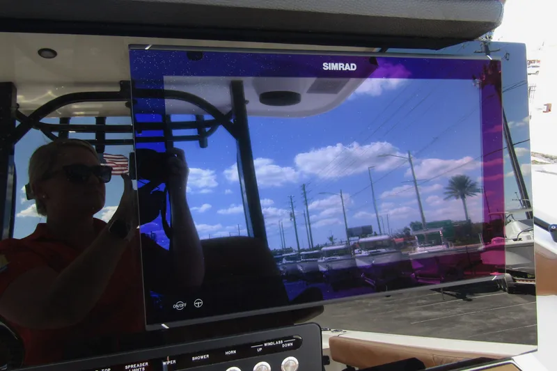 Slide: The Image of 2025 Sea Pro 322 Offshore boat with Simrad display reflecting sky and surroundings. - 25