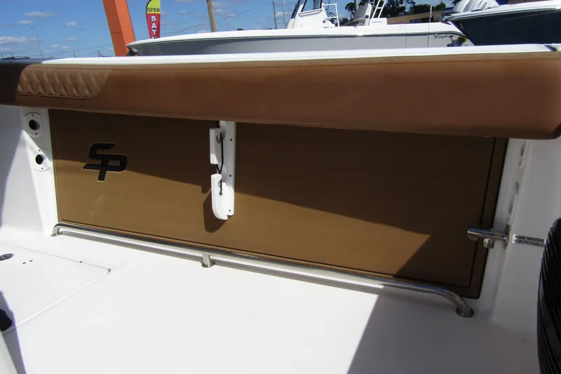 Slide: The Image of 2025 Sea Pro 322 Offshore boat interior with brown cushioned seating and logo detail. - 33