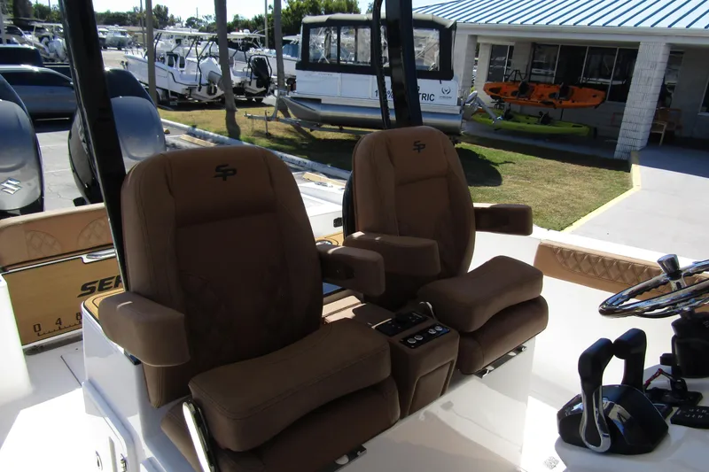 Slide: The Image of 2025 Sea Pro 322 Offshore boat interior with brown captain seats and control panel. - 22