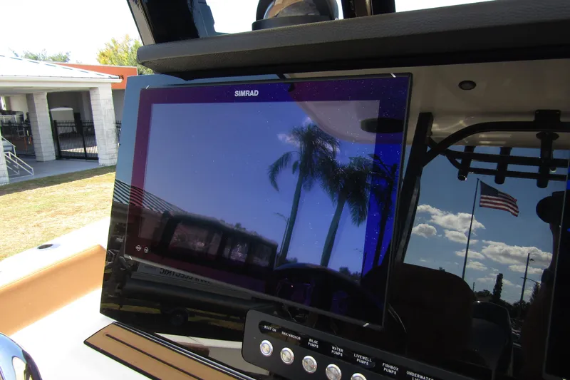 Slide: The Image of Simrad display on 2025 Sea Pro 322 Offshore boat, reflecting palm trees and American flag. - 26