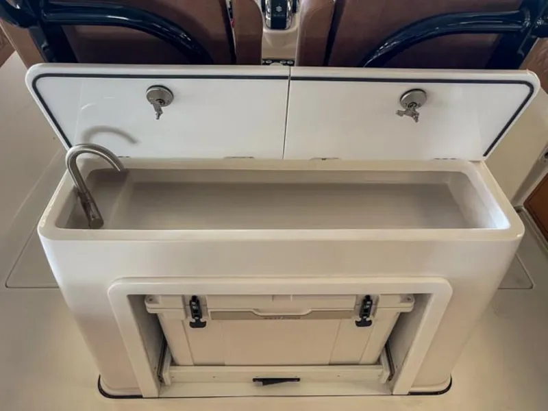 Slide: The Image of 2025 Sea Pro 322 Offshore boat interior with open storage compartments and cushioned seating. - 7