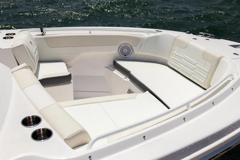 Slide: The Image of 2025 Edgewater 262 CX boat interior with white seating and cup holders on the water. - 15