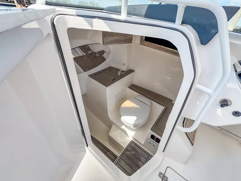 Slide: The Image of 2025 Edgewater 262 CX boat interior with compact bathroom and modern amenities. - 27