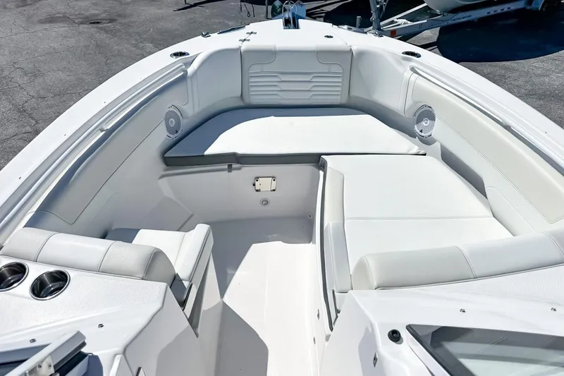 Slide: The Image of 2025 Edgewater 262CX Crossover boat interior with white seating and cup holders. - 41