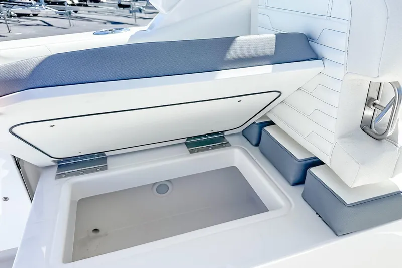 Slide: The Image of 2025 Edgewater 262CX Crossover boat seat storage compartment open, showcasing interior space. - 49