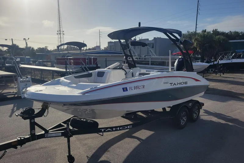 Slide: The Image of 2023 Tahoe 1950 boat on trailer in outdoor showroom, sunny day. - 5
