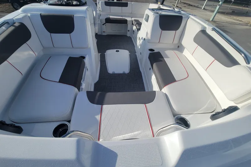 Slide: The Image of 2023 Tahoe 1950 boat interior with white and gray seating, red accents, and cup holders. - 9
