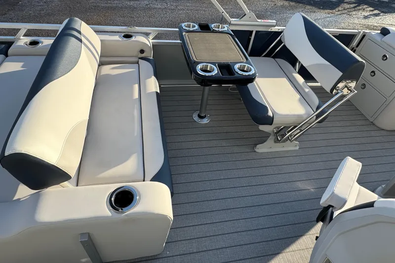 Slide: The Image of 2026 Avalon LSZ Entertainer boat interior with seating and table, featuring cup holders. - 13