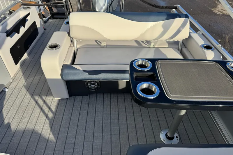 Slide: The Image of 2026 Avalon LSZ Entertainer boat interior with seating and table, featuring cup holders. - 15