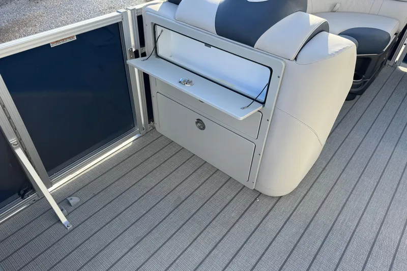 Slide: The Image of 2026 Avalon LSZ Entertainer boat interior with storage compartment and seating. - 16