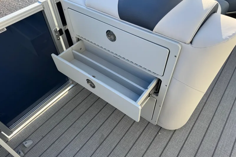 Slide: The Image of 2026 Avalon LSZ Entertainer boat interior with open storage drawer on deck. - 17