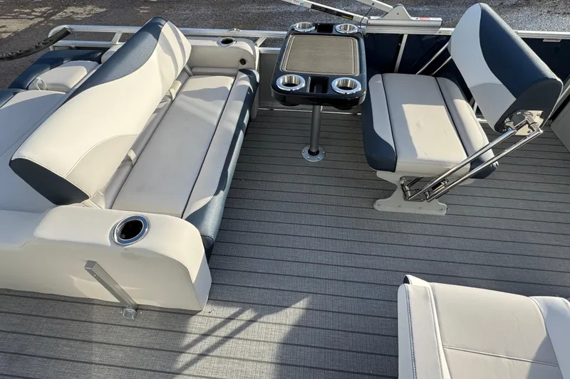 Slide: The Image of 2026 Avalon LSZ Entertainer boat interior with seating and table, featuring cup holders. - 7