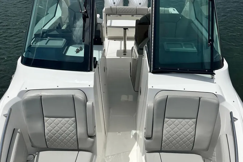 Slide: The Image of 2023 Pursuit DC 295 Dual Console boat interior with cushioned seating and windshield. - 11