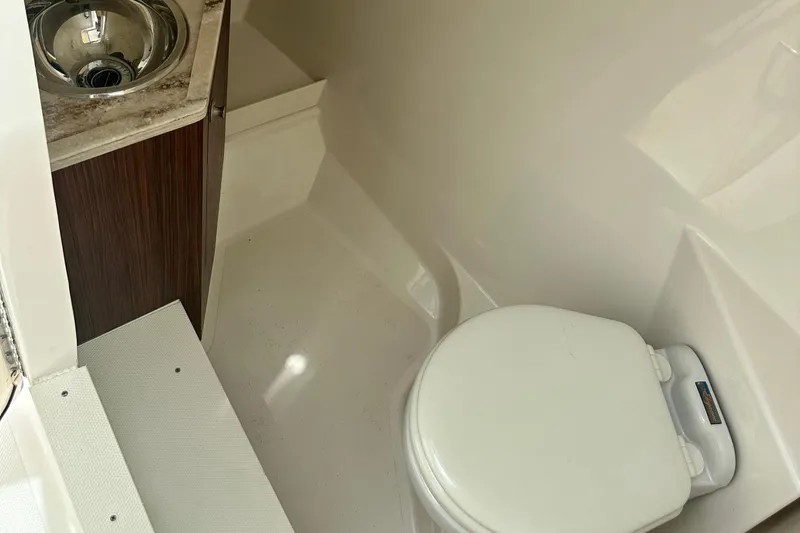 Slide: The Image of 2023 Pursuit DC 295 Dual Console boat bathroom with sink and toilet. - 18