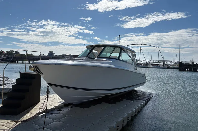 Slide: The Image of 2023 Pursuit DC 295 Dual Console boat docked at marina under clear sky. - 5