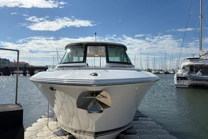 Slide: The Image of 2023 Pursuit DC 295 Dual Console boat docked in a sunny marina. - 6