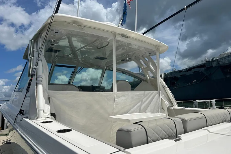 Slide: The Image of 2023 Pursuit DC 295 Dual Console boat docked under cloudy sky. - 8