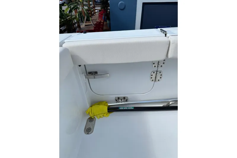 Slide: The Image of 2024 Sea Hunt Gamefish 27 boat interior with storage compartment and yellow gloves. - 10