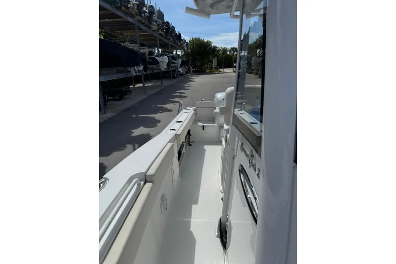 Slide: The Image of 2024 Sea Hunt Gamefish 27 Forward Seating boat, docked with visible interior walkway. - 23