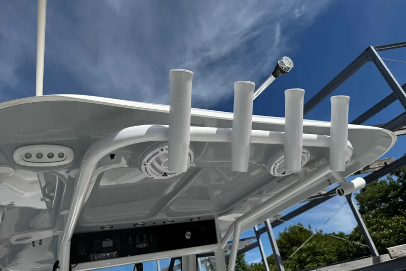 Slide: The Image of 2024 Sea Hunt Gamefish 27 boat with rod holders and speakers under a clear sky. - 9