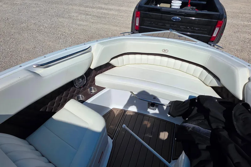 Slide: The Image of Interior of a 2013 Cobalt A25 boat with white seating and wood flooring. - 15