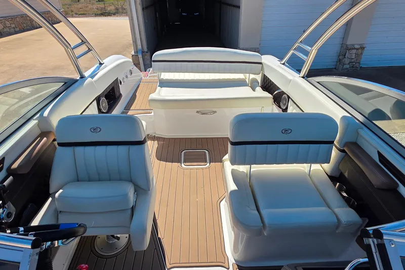 Slide: The Image of Interior of a 2013 Cobalt A25 boat with white seating and wood flooring. - 16