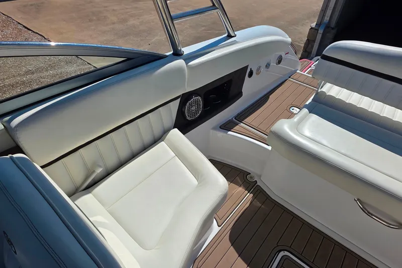 Slide: The Image of 2013 Cobalt A25 boat interior with white seating and wood flooring. - 17