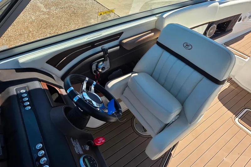 Slide: The Image of Captain's seat and steering wheel of 2013 Cobalt A25 boat, featuring sleek design and controls. - 18