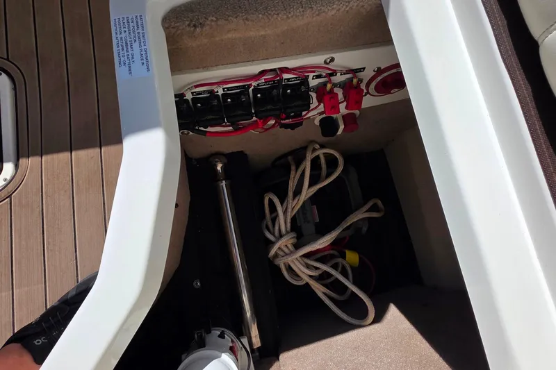 Slide: The Image of Storage compartment of a 2013 Cobalt A25 boat with electrical panel and rope. - 25