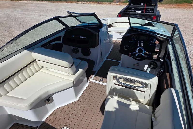 Slide: The Image of 2013 Cobalt A25 boat interior with beige seating and sleek dashboard design. - 8