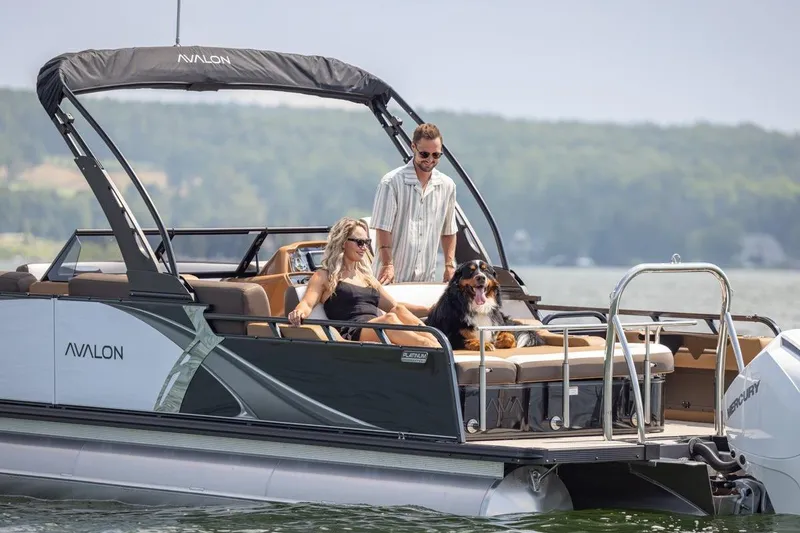 Slide: The Image of 2026 Avalon LSZ CRB pontoon boat with passengers and a dog on a lake. - 4