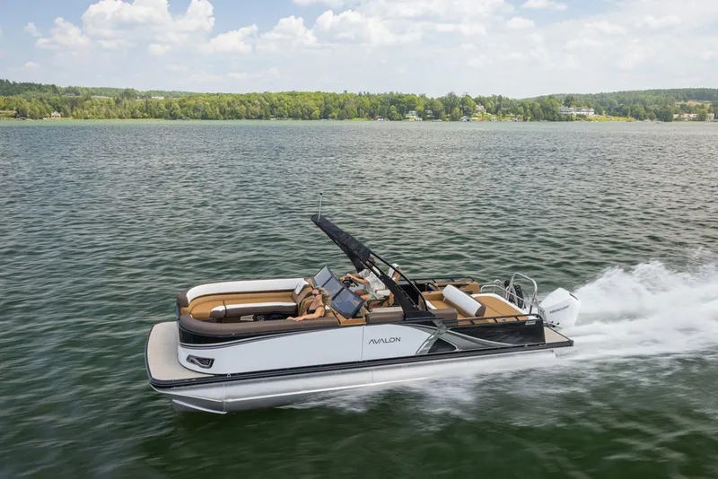 Slide: The Image of 2026 Avalon LSZ CRB pontoon boat cruising on a scenic lake. - 8