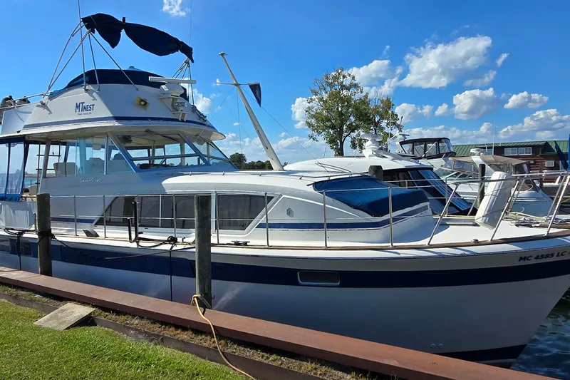 The Image of 1979 Chris-Craft 410 Motor Yacht docked under clear blue sky. - 1
