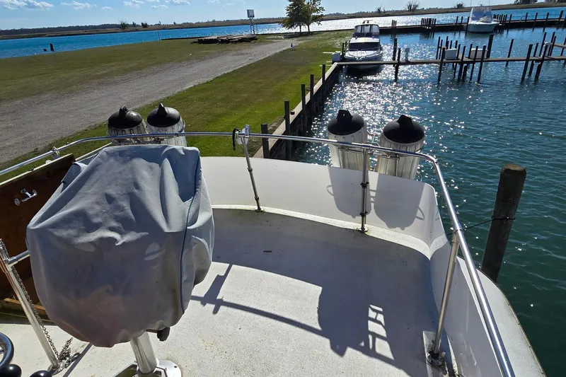 Slide: The Image of 1979 Chris-Craft 410 Motor Yacht docked by a serene waterfront under clear skies. - 10
