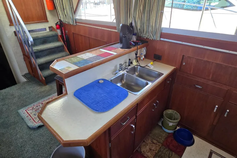 Slide: The Image of 1979 Chris-Craft 410 Motor Yacht interior with kitchen sink and wooden cabinetry. - 14
