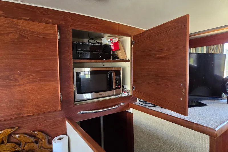 Slide: The Image of 1979 Chris-Craft 410 Motor Yacht interior with microwave and wooden cabinets. - 15