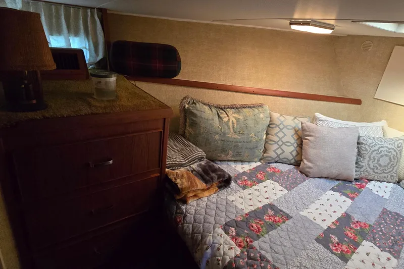 Slide: The Image of Cozy cabin interior of 1979 Chris-Craft 410 Motor Yacht with quilted bedding and pillows. - 17
