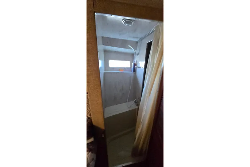 Slide: The Image of Shower area inside 1979 Chris-Craft 410 Motor Yacht, featuring a window and curtain. - 20