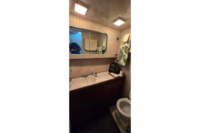 Slide: The Image of Bathroom interior of 1979 Chris-Craft 410 Motor Yacht with sink, mirror, and toilet. - 21