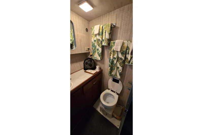 Slide: The Image of 1979 Chris-Craft 410 Motor Yacht bathroom with floral towels and compact amenities. - 22