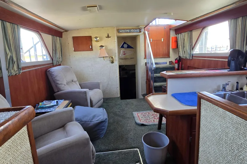 Slide: The Image of 1979 Chris-Craft 410 Motor Yacht interior with cozy seating and kitchenette. - 23