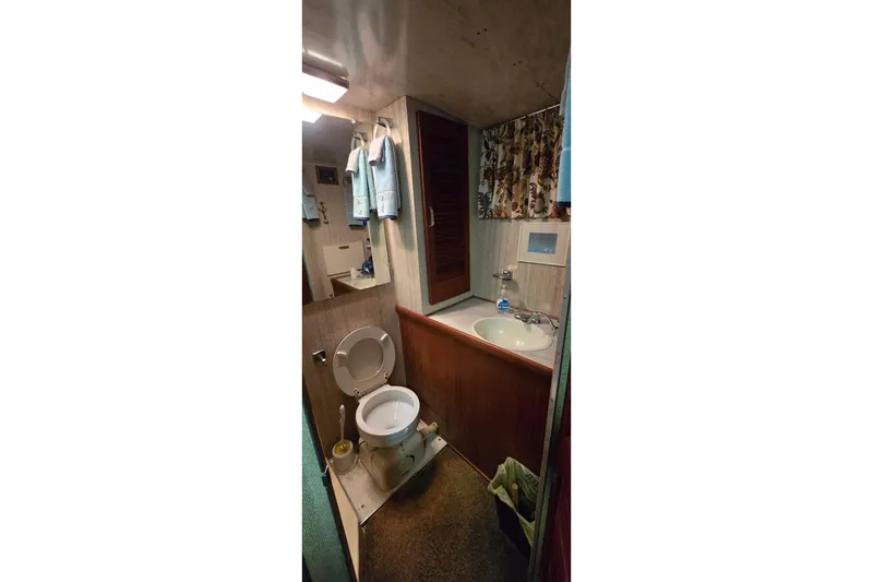Slide: The Image of 1979 Chris-Craft 410 Motor Yacht bathroom with sink, toilet, and towels. - 26